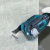 A person is using a cordless oscillating multi-tool to cut into a concrete wall. Produktbild-Vorschau