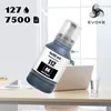 A bottle of black ink refill is placed on a desk next to a laptop and a glass of water. Náhled obrázku produktu