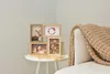 A multi-photo frame collage sits on a small white table next to a couch with a knitted blanket. Náhled obrázku produktu