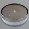 A close-up, top-down view of a round, metallic and white product against a plain gray background. Produktbild-Vorschau