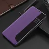 A purple smartphone case with a smart view window is placed on a black surface, next to a brown notebook. Produktbild-Vorschau