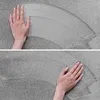 A hand is shown wiping a surface, leaving a curved mark. Náhled obrázku produktu