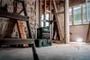 A man is working in a room under renovation, with tools and equipment around him. Podgląd zdjęcia produktu