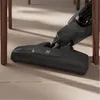 Close-up of a vacuum cleaner head on a wooden floor, near table legs. Voir les images du produit