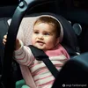 A baby is sitting in a car seat. Anteprima dell’immagine prodotto