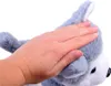 A hand petting a stuffed husky dog. Produktbild-Vorschau