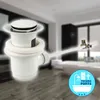 A white bathroom drain assembly is shown in the foreground, with a blurred background of a modern bathroom with a bathtub. Produktbild-Vorschau