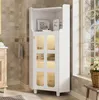 A white corner cabinet with glass doors is shown in a bathroom setting. Produktbild-Vorschau