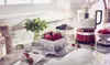 A kitchen counter with a red food processor, strawberries, blueberries, raspberries, and mint. Produktbild-Vorschau