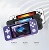 Three ANBERNIC portable game consoles in different colors (purple, black, and white) are displayed in a stacked, diagonal arrangement against a light gray and white background. The screens of the consoles show racing game graphics. Text labels for each col Produktbild-Vorschau