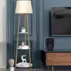 A floor lamp with shelves is placed next to a TV stand and a speaker. Podgląd zdjęcia produktu