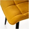 A close-up view of a mustard yellow upholstered chair with black legs. Náhled obrázku produktu