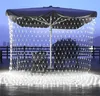Outdoor patio area at dusk with umbrella and string lights. Náhled obrázku produktu