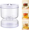A clear product shot of a clear plastic food storage container with a white lid, shown on a white background. To the right are smaller inset images showing the container filled with different foods and liquids. Náhľad obrázku produktu