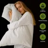 A woman is holding a pillow, with feature callouts on the right side. Produktbild-Vorschau