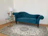 A teal chaise lounge is placed on an ornate rug in a room with a white wall and a corner. Produktbild-Vorschau
