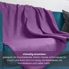 A purple fleece blanket draped over a blue sofa. Produktbild-Vorschau