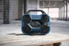 A Bosch professional radio sits on a wooden pallet in a construction site. Produktbild-Vorschau