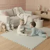 Two babies playing on a puzzle mat in a living room. Anteprima dell’immagine prodotto