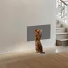 A Bengal cat is scratching a gray textured panel mounted on a white wall, with a staircase in the background. Produktbild-Vorschau