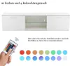 A white TV stand with a remote control and color swatches below. Produktbild-Vorschau