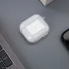 A clear case for Apple AirPods is placed on a gray surface next to a laptop keyboard. Produktbild-Vorschau