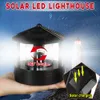 A hand holding a solar-powered lighthouse decoration at night, with a background of a starry sky and a distant lighthouse. Anteprima dell’immagine prodotto