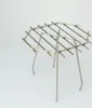 A metal grill rack with three legs, shown against a white background. Produktbild-Vorschau