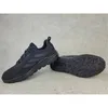 A pair of black Adidas Terrex Anylander outdoor hiking shoes are displayed on a gray concrete surface. Produktbild-Vorschau