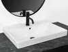 A white rectangular sink with a black faucet is shown on a black marble countertop, with a black circular mirror in the background. Podgląd zdjęcia produktu