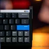 A close-up view of a black gaming keyboard with blue and gray keys, featuring the brand name 'EZ63'. Produktbild-Vorschau