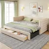 A beige upholstered daybed with a pull-out trundle bed and storage drawers, set up in a room with light green curtains and wall art. Náhled obrázku produktu