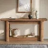 A wooden console table with decorative items on it, placed in a room with a rug and a framed picture on the wall. Podgląd zdjęcia produktu