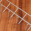 A metal hook rack with several hooks against a wooden background. Produktbild-Vorschau