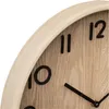 A close-up view of a wooden wall clock face, showing the numbers 10, 11, and 12, and the clock hands. Náhled obrázku produktu