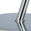 Close-up of the base of a metallic table leg on a round metallic surface. Voir les images du produit