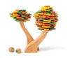 A wooden balancing game shaped like two trees with colorful discs stacked on them, and two dice in front. Voir les images du produit