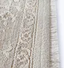 A close-up view of a beige rug with a fringed edge. Produktbild-Vorschau