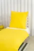 A yellow duvet and pillow set on a white bed frame. Podgląd zdjęcia produktu