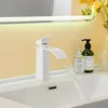 A white waterfall faucet in a bathroom sink with water flowing. Náhľad obrázku produktu