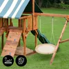 A wooden playground set with a nest swing and slide, set up on a grassy lawn. Produktbild-Vorschau