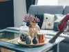 A cordless vacuum cleaner is being used to clean a coffee table in a living room. Produktbild-Vorschau
