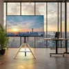 A modern office or living space with large windows overlooking a city skyline at sunset. A TV stand with a large screen is prominently displayed in the foreground. Produktbild-Vorschau