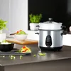 A rice cooker is shown on a kitchen counter next to prepared food. Produktbild-Vorschau