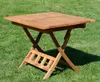 A wooden folding table is set up on a grassy lawn. Produktbild-Vorschau