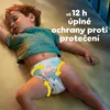 A sleeping baby wearing diapers with yellow arrows indicating protection. Náhled obrázku produktu