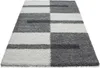 A shaggy rug with a checkered pattern of gray and white squares and rectangles, laid out on a white background. Náhľad obrázku produktu