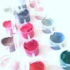 A close-up view of multiple small containers filled with colorful paints. Produktbild-Vorschau