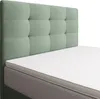 A close-up view of a bed with a green tufted headboard and a white mattress topper. Produktbild-Vorschau