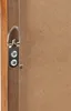 A close-up view of the back of a picture frame, showing a metal hanging hook attached to the wooden frame with screws. Voir les images du produit
